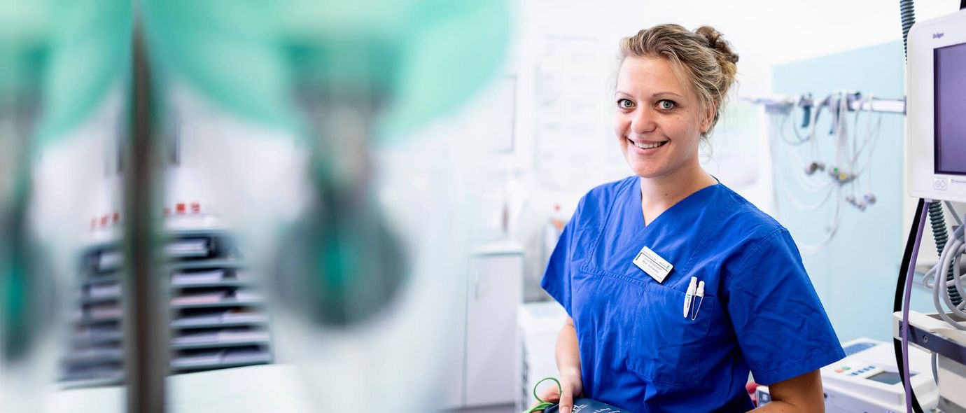 Pflegekraft hält Messgerät im Patientenzimmer