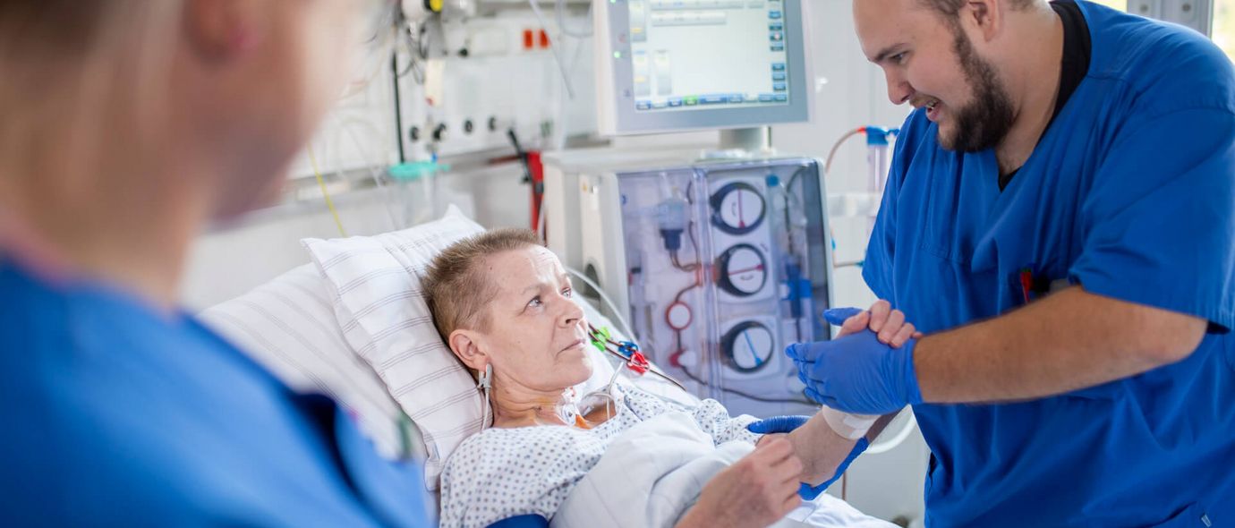 Männliche Pflegekräfte kümmern sich um neurologische Patientin