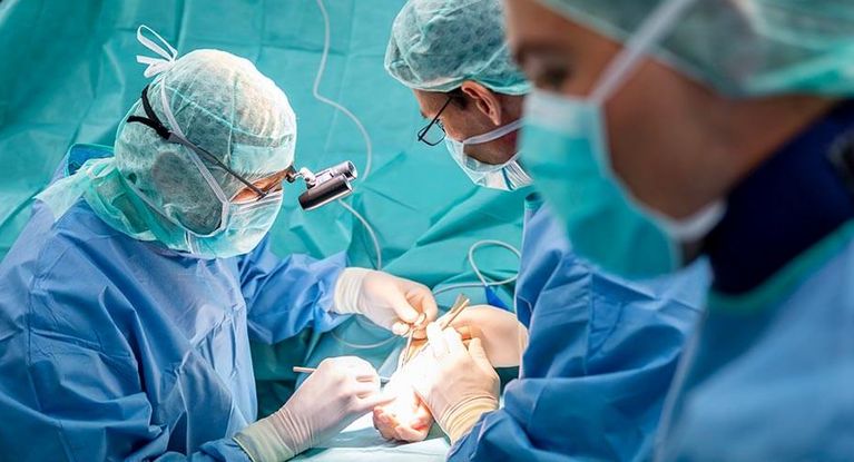 Ärztetam opertiert Hand eines Patienten