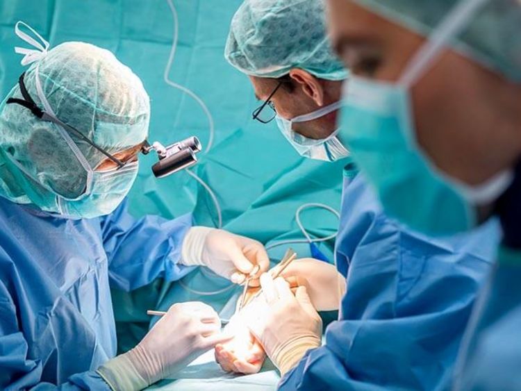 Ärztetam opertiert Hand eines Patienten