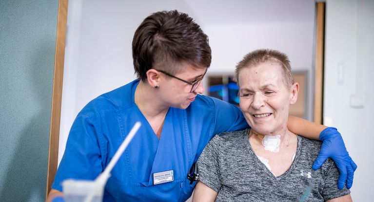 Männliche Pflegekraft betreut neurologische Patientin