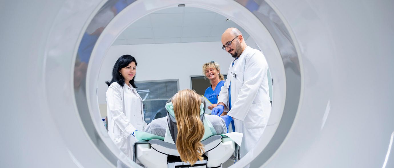 Arzt und Pflegekraft bereiten Patienten auf CT-Scan vor