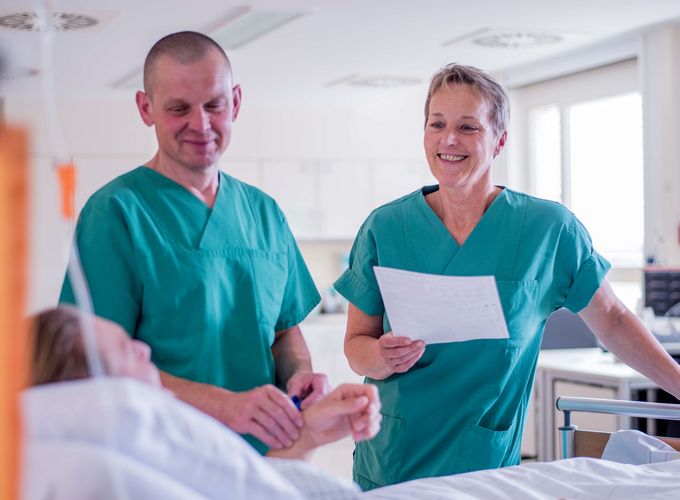 Pföegekräfte kümmern sich um Patienten im Aufwachraum