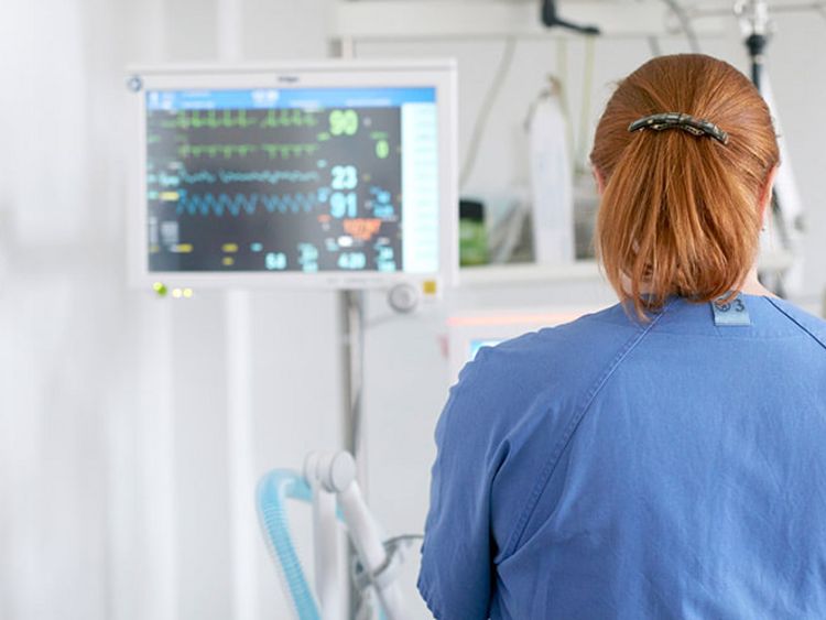 Pflegekräfte prüfen Vitalwerte am Bildchirm