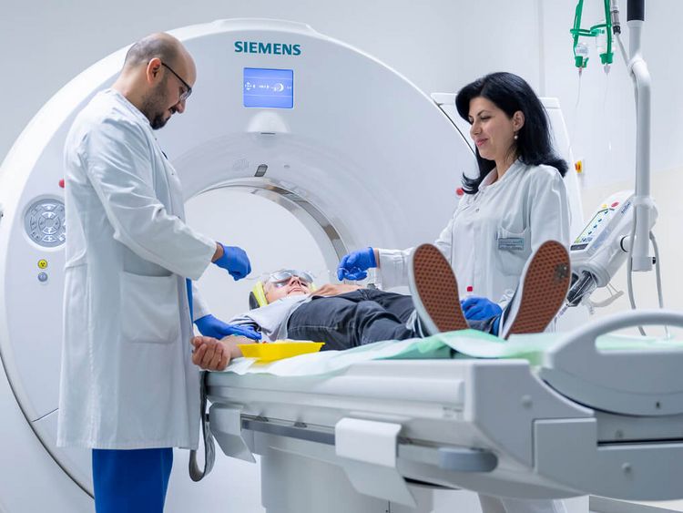 Arzt und Pflegekraft bereiten Patienten auf CT-Scan vor