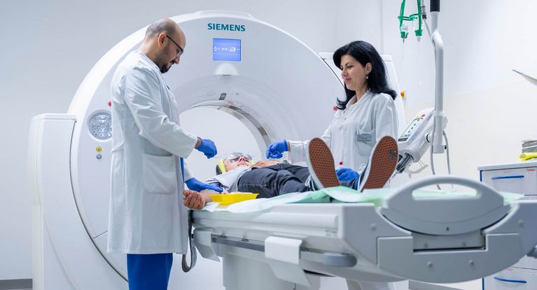 Arzt und Pflegekraft bereiten Patienten auf CT-Scan vor