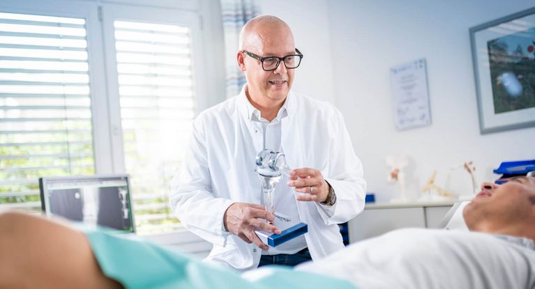 Orthopäde untersucht Knie eines Patienten