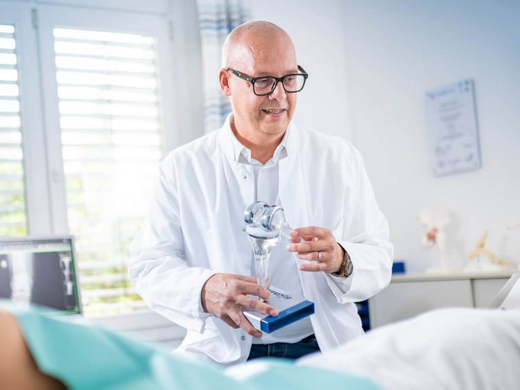 Orthopäde untersucht Knie eines Patienten